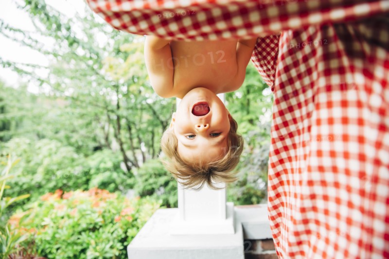 Baby boy hanging upside down outdoors