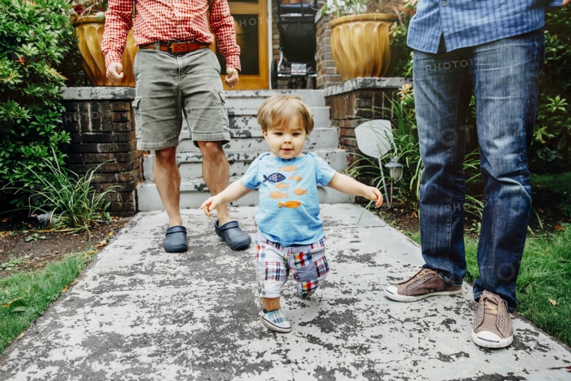 Gay fathers and baby son standing outdoors