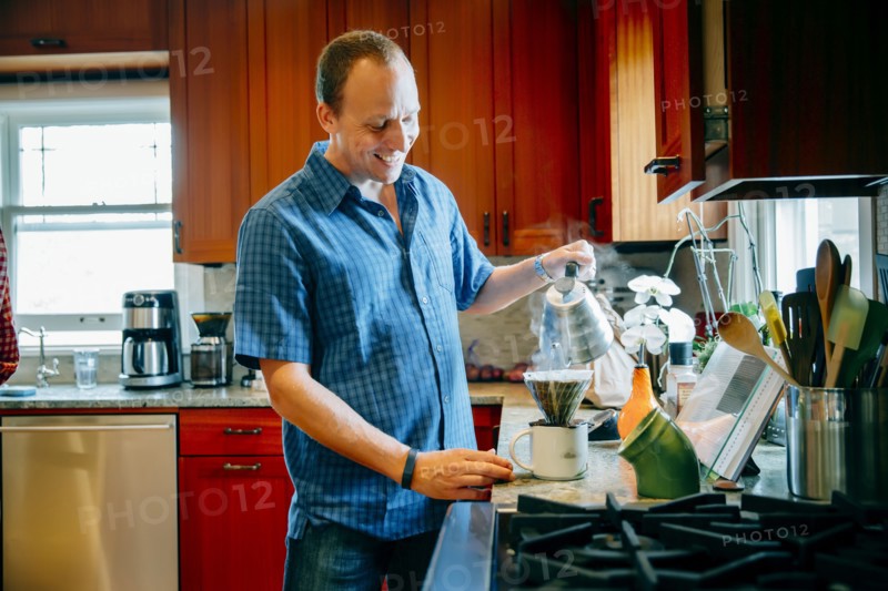 Caucasian man pouring coffee in kitchen