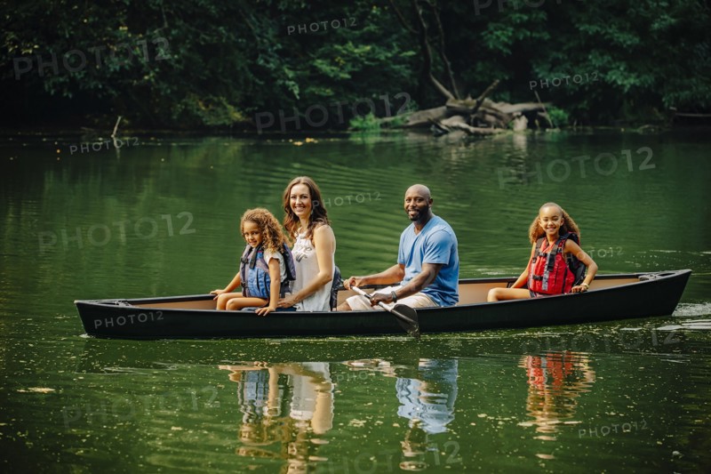 Family sitting in canoe in lake