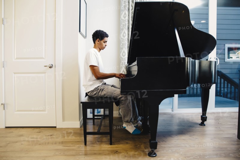 Mixed race boy playing piano