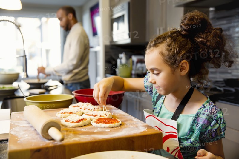 Mixed race girl cooking in kitchen