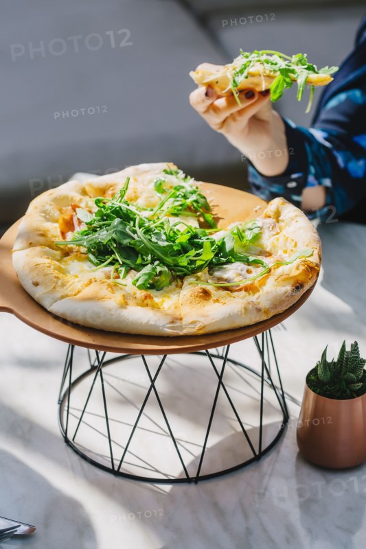 Caucasian woman eating pizza in cafe