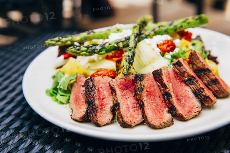 Plate of grilled meat and asparagus salad