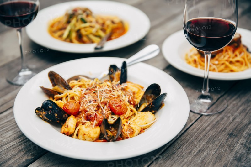 Plates of seafood and pasta with wine glasses