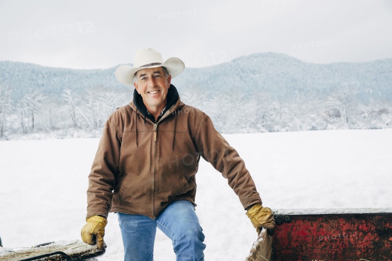 Caucasian farmer smiling in snowy field