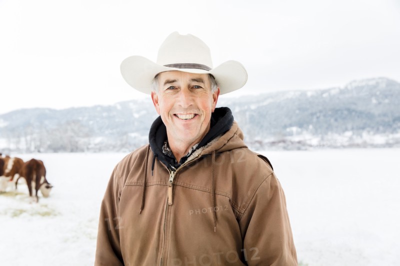 Caucasian farmer smiling in snowy field