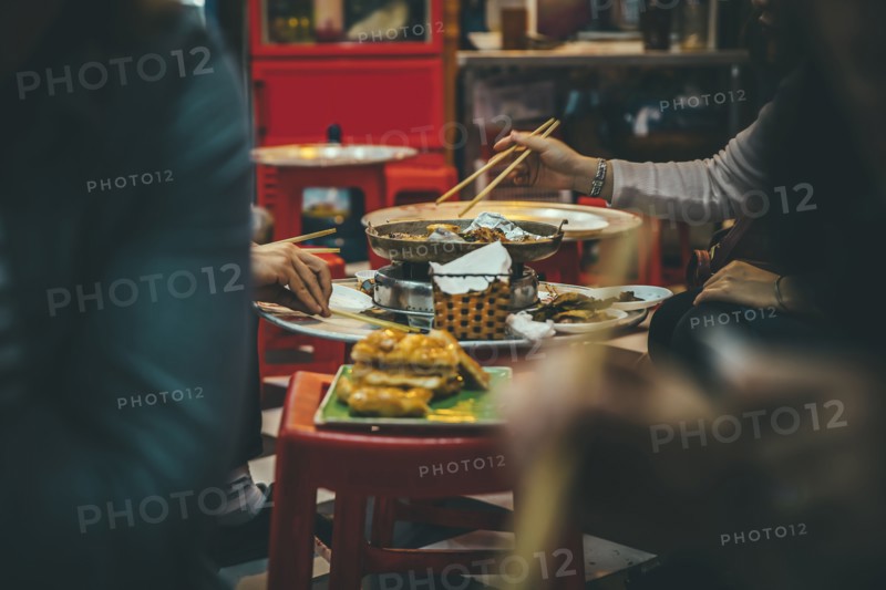 People eating with chopsticks in restaurant