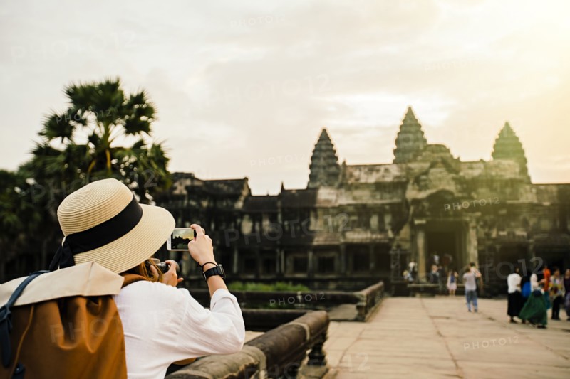Caucasian tourist photographing Angkor Wat ruins