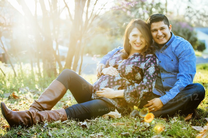 Pregnant Hispanic couple smiling outdoors