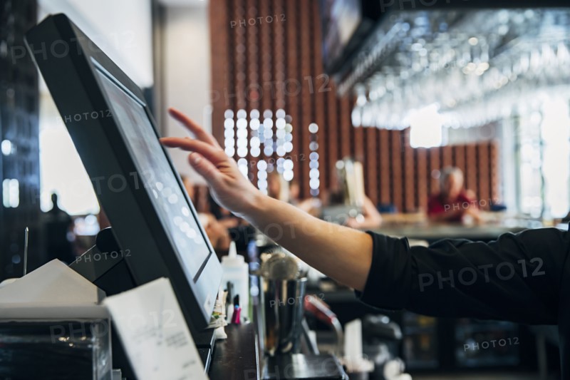 Caucasian  bartender using computer