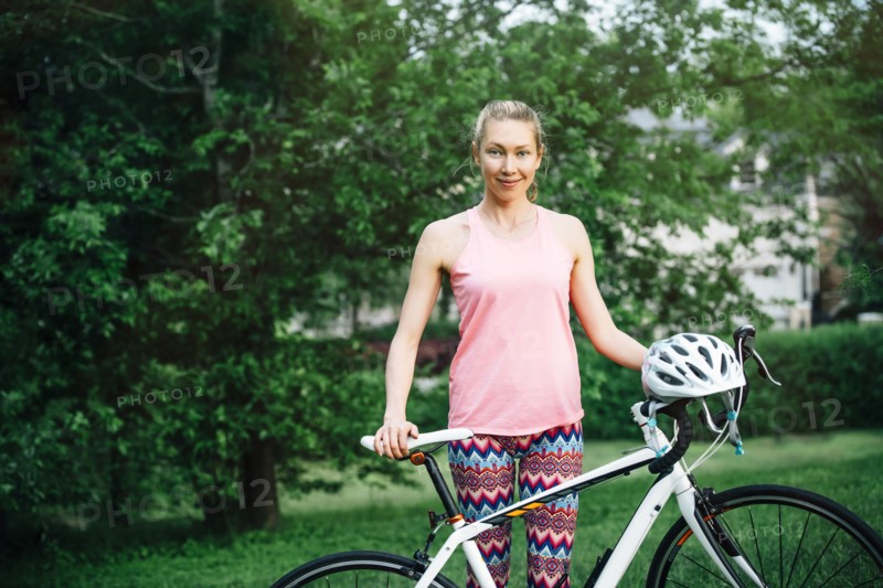 Smiling Caucasian woman posing holding bicycle