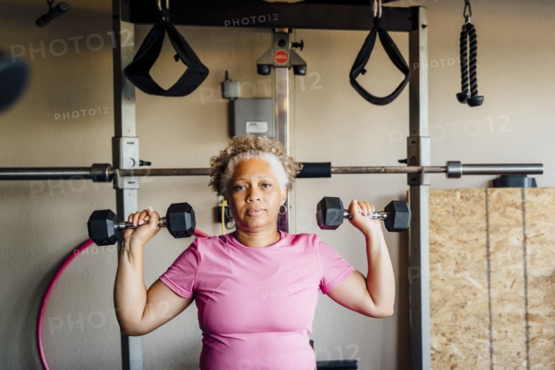 Black woman lifting weights in garage