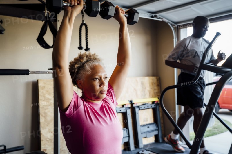 Black couple lifting working out in garage