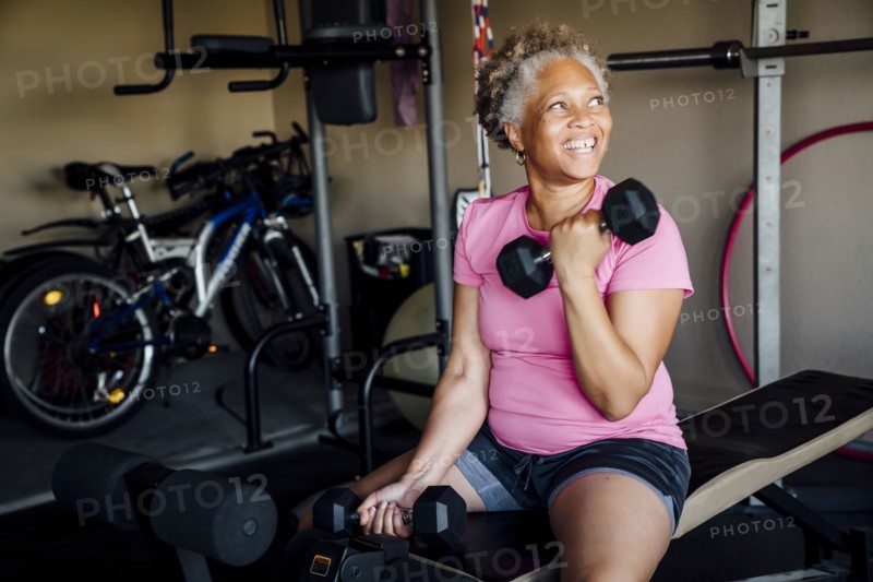 Black woman lifting weights in garage