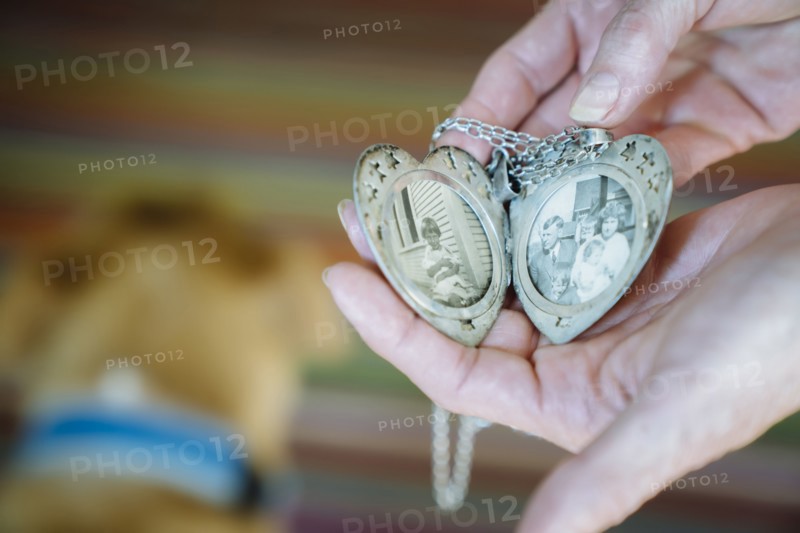 Hands of Caucasian woman showing photographs in cameo