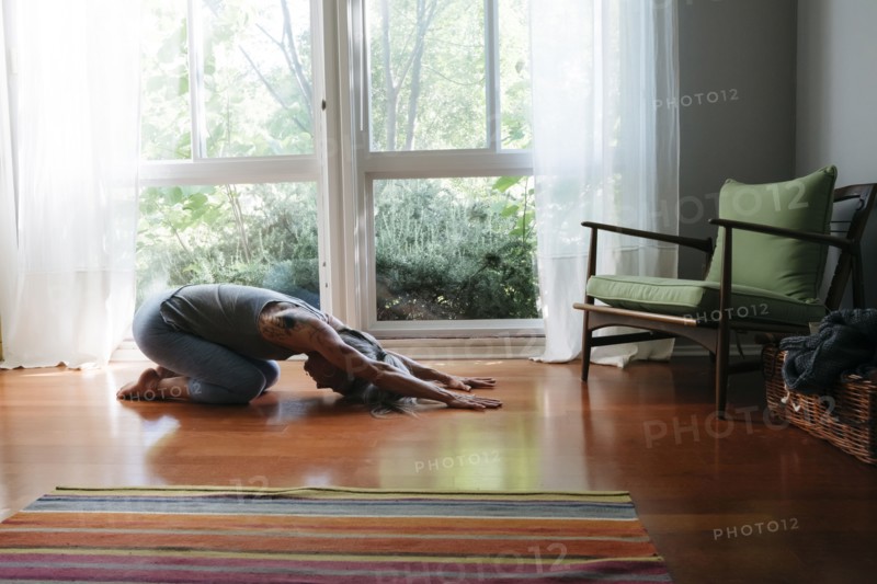 Caucasian woman kneeling on floor stretching