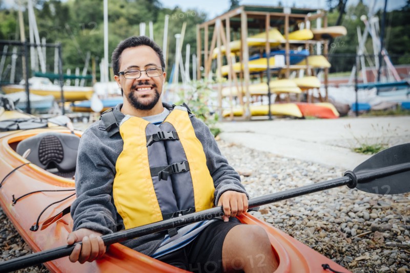 Mixed Rave man sitting in kayak holding paddle