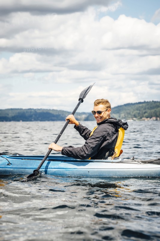 Caucasian man paddling kayak
