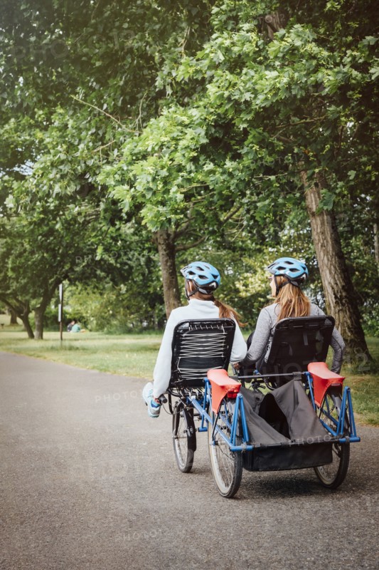 Caucasian mother and daughter riding tandem bicycle