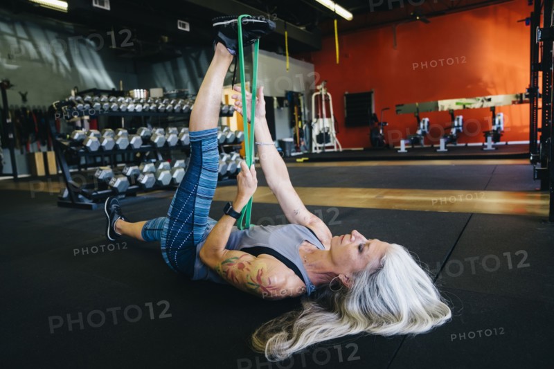 Caucasian woman stretching leg with resistance band