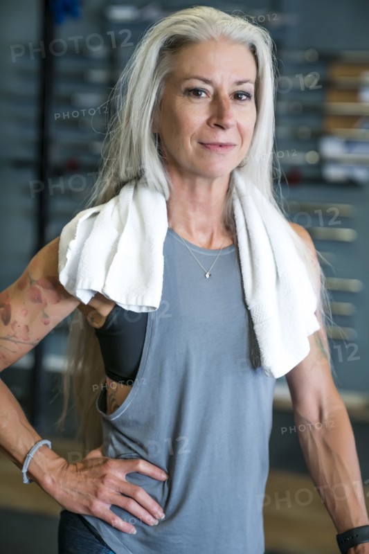 Caucasian woman posing in gymnasium wearing towel