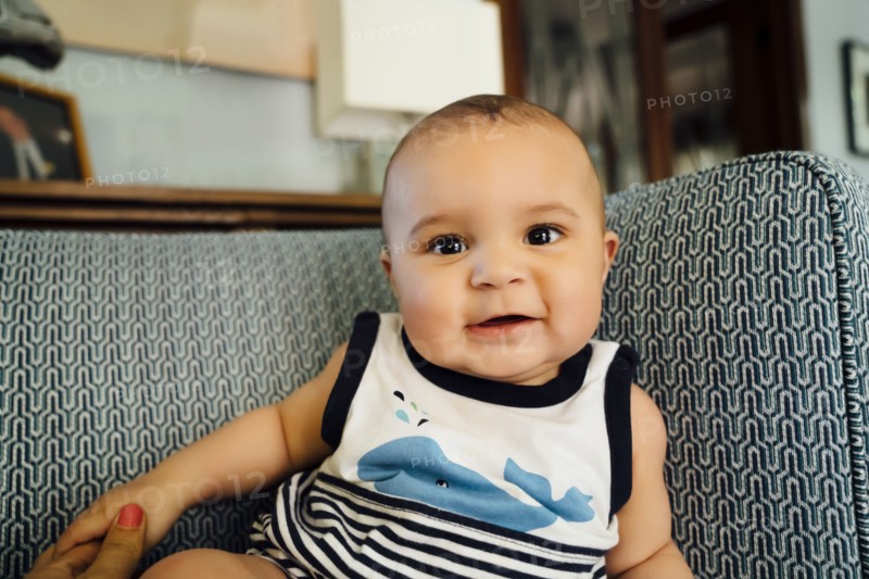 Portrait of smiling Mixed Race baby boy on chair