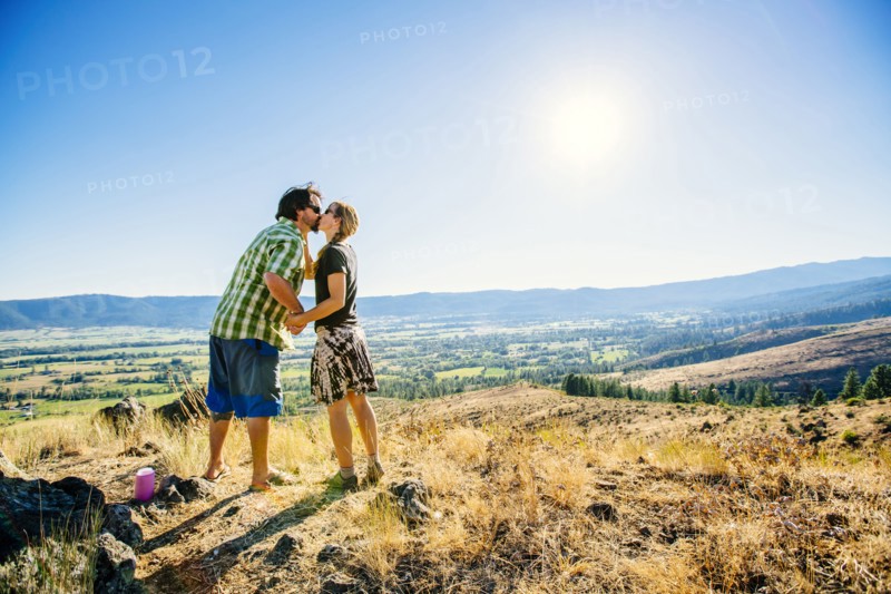 Caucasian couple standing on hill and kissing