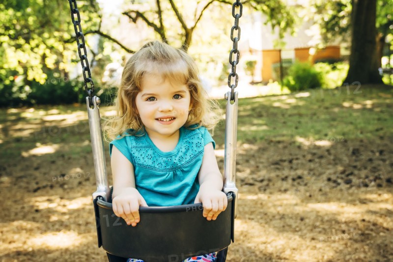 Caucasian preschool girl sitting in swing