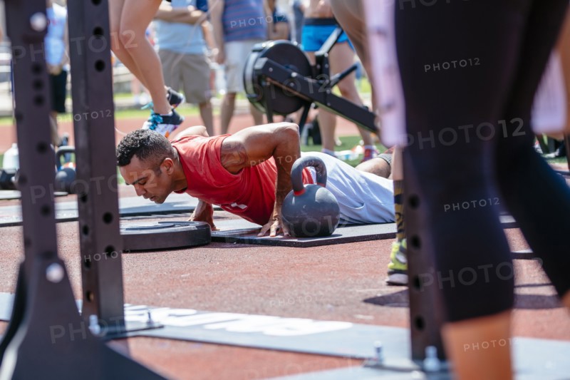 Man doing push-ups near kettlebell outdoors