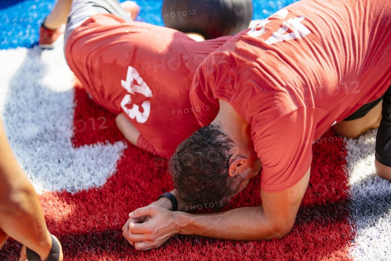 Fatigued men resting on artificial turf field