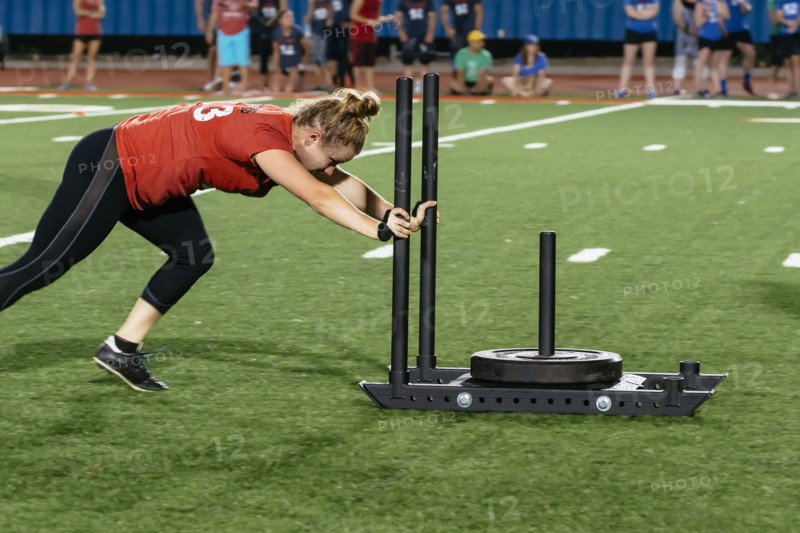 Caucasian woman pushing weight on sports field