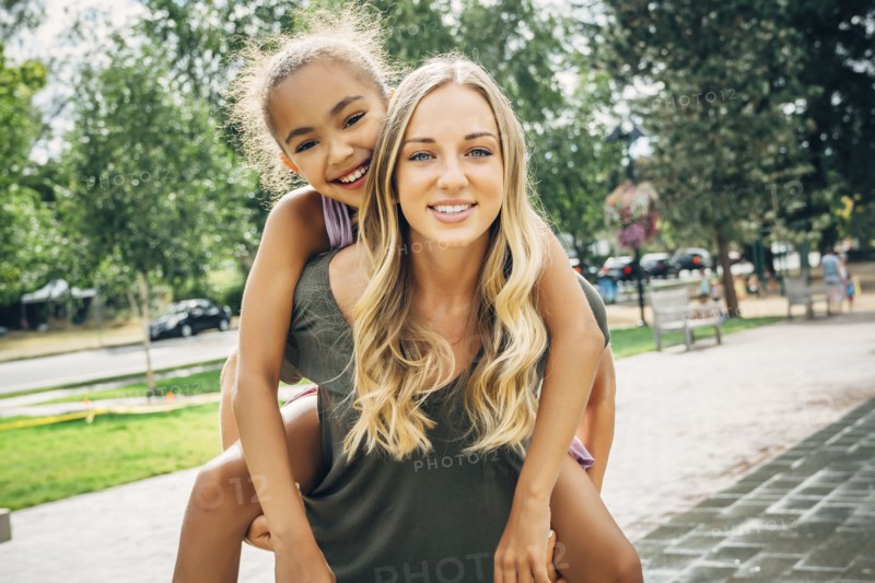 Smiling woman carrying sister piggyback