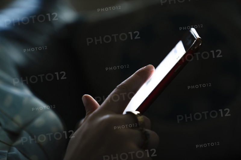 Woman texting on cell phone in the dark