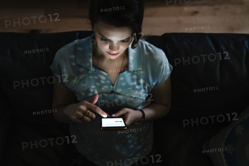 Woman texting on cell phone in the dark