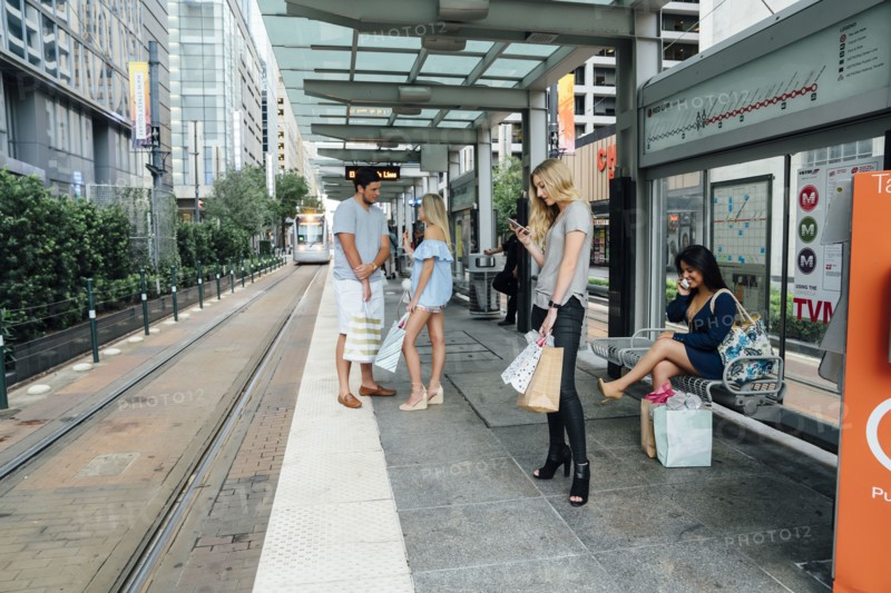 People at train station using cell phones