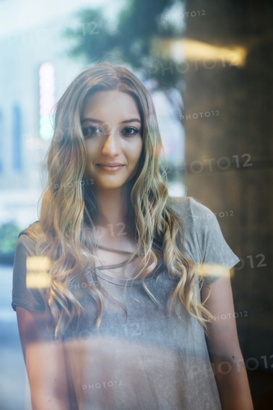 Portrait of serious Caucasian woman behind window