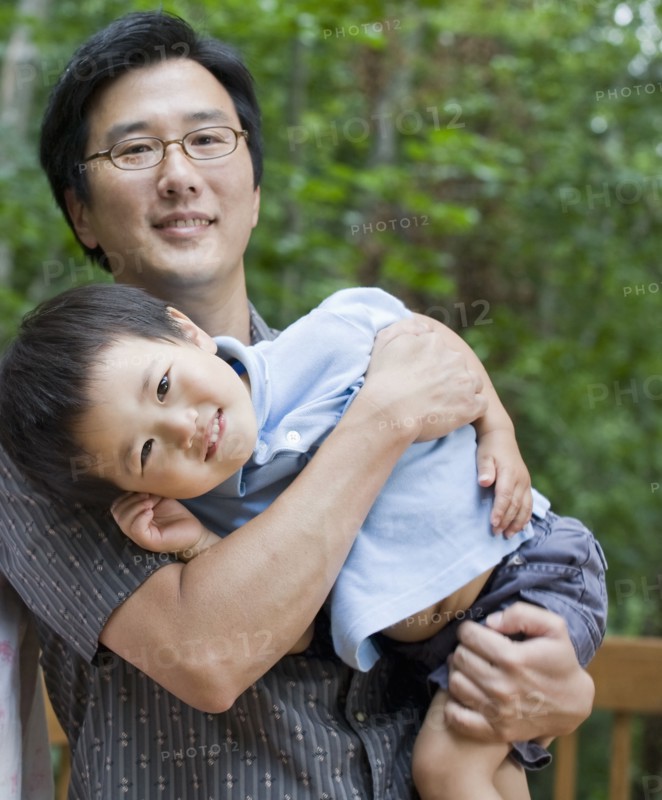 Asian father carrying son