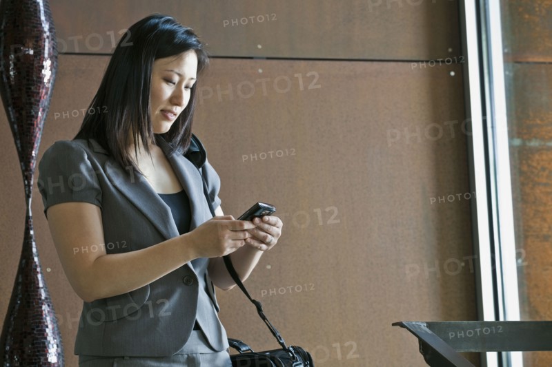 Asian businesswoman looking at cell phone