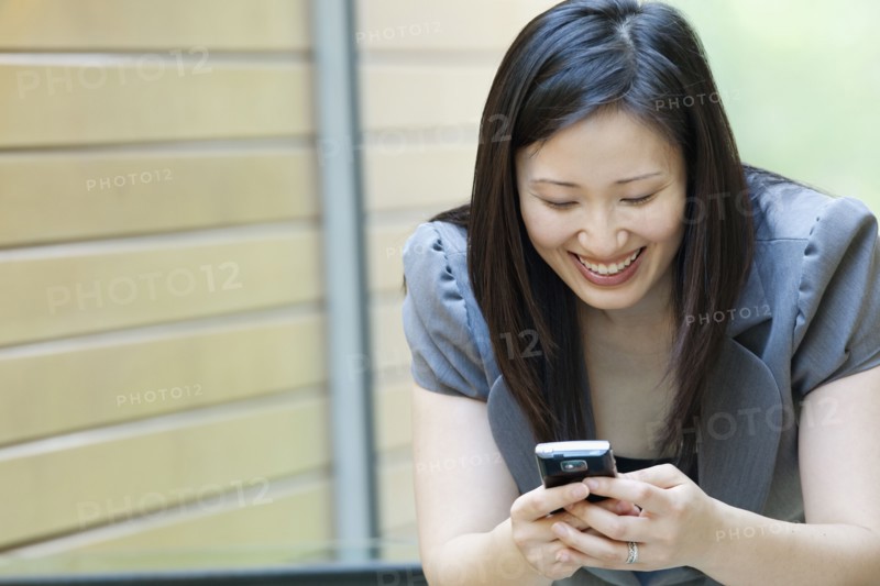 Asian businesswoman looking at cell phone