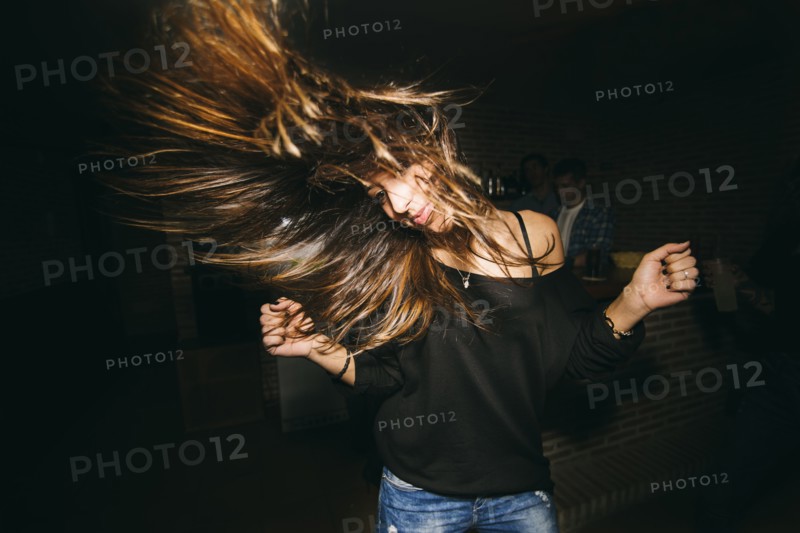 Woman tossing her hair and dancing in nightclub
