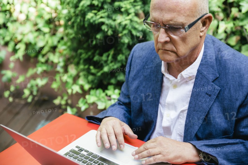 Hispanic businessman using laptop outdoors