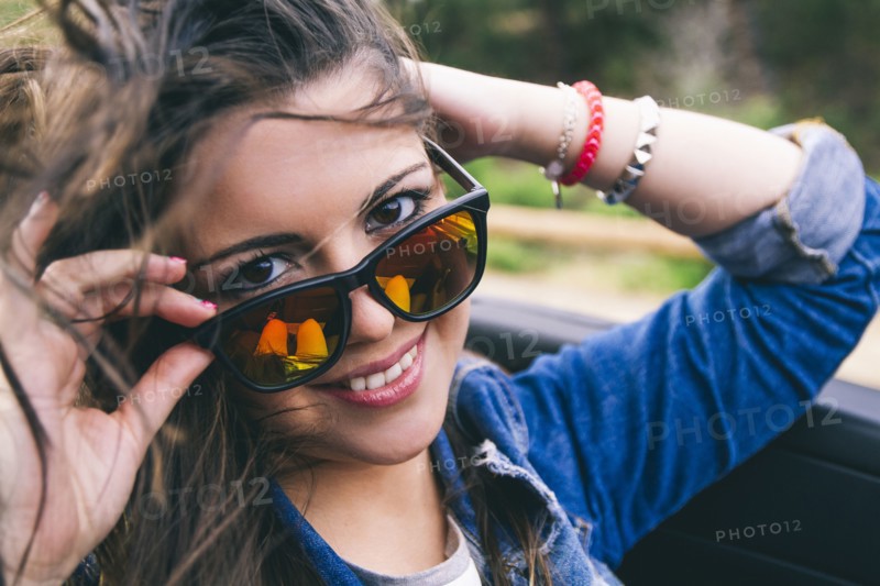 Hispanic woman peering over sunglasses