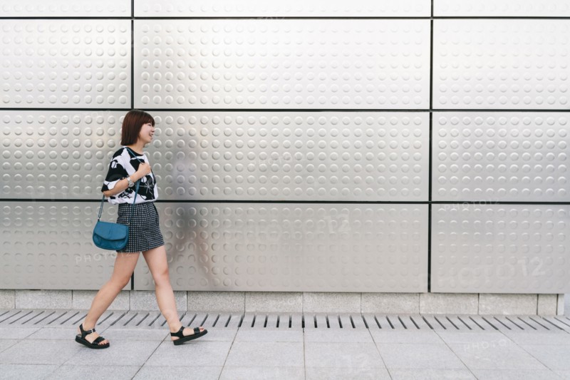 Chinese woman walking on sidewalk