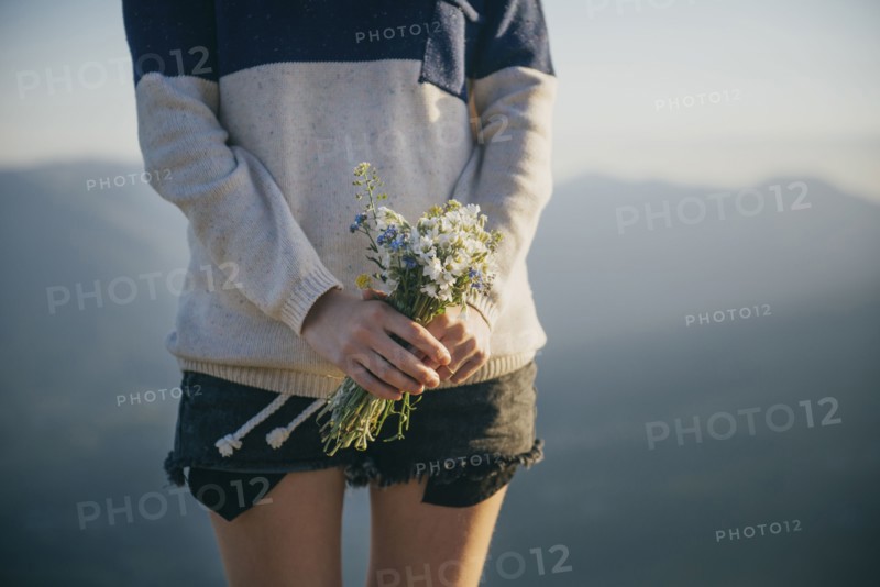 Caucasian woman holding bouquet of wildflowers