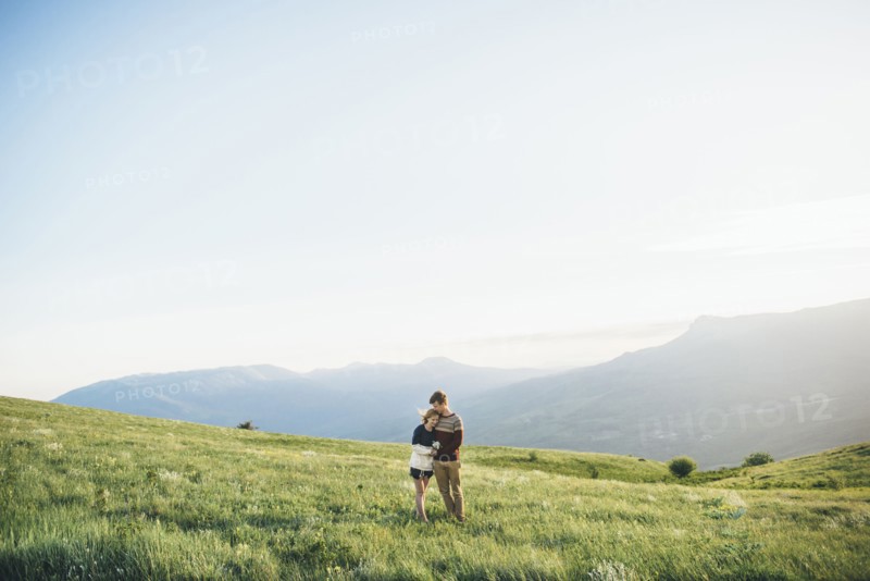 Caucasian couple hugging in field