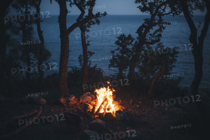 Campfire at night near ocean