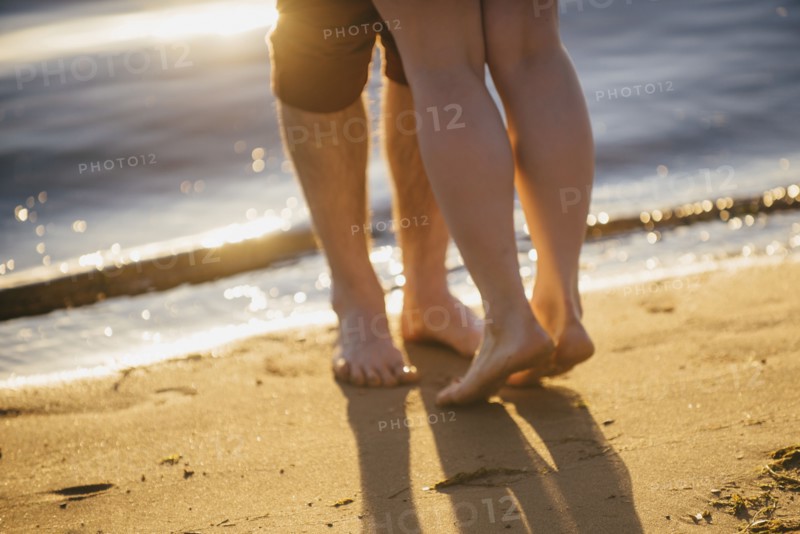 Legs of couple hugging at beach