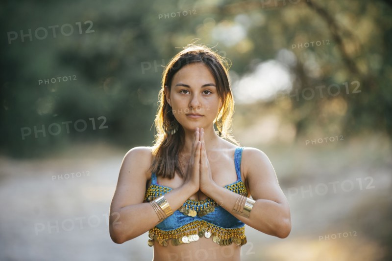 Caucasian belly dancer with hands clasped