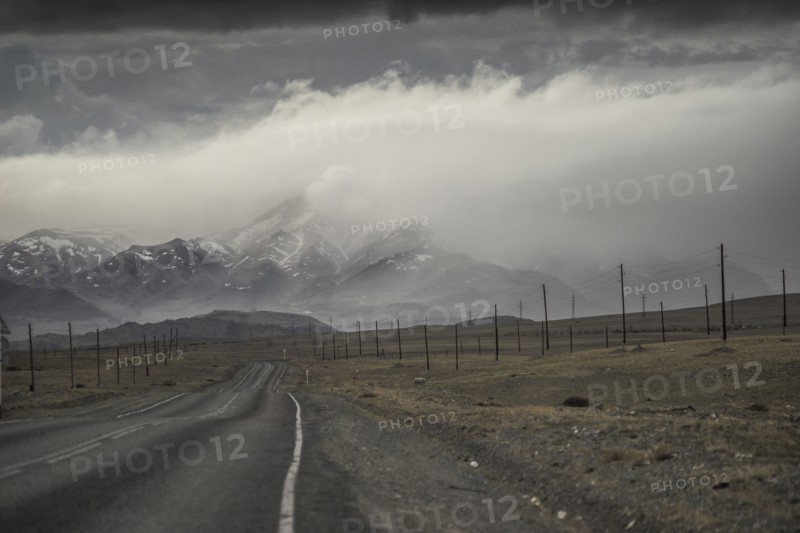 Clouds over road to mountain landscape